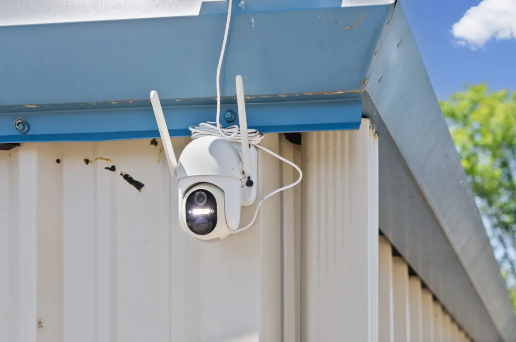 Military storage facility security camera mounted on exterior building